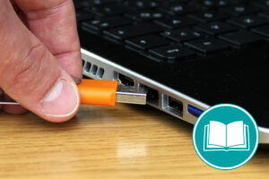 Ein USB-Stick wird in einen Laptop gesteckt