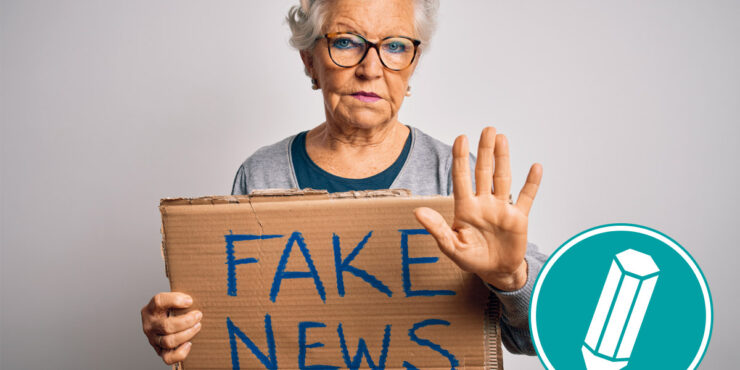 Ältere Frau hält ein Schild hoch auf dem steht: Fake News