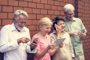 4 Senior*innen schauen auf ihr Smartphone