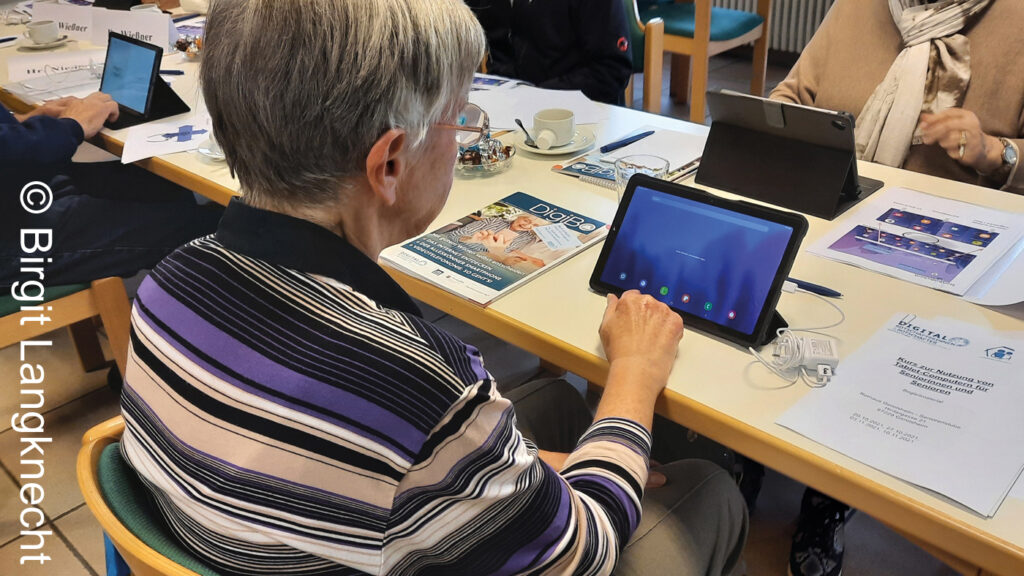Eine Frau tippt auf den Startbildschirm am Tablet.