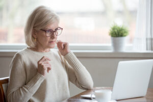 Überraschte ältere Frau vor Laptop